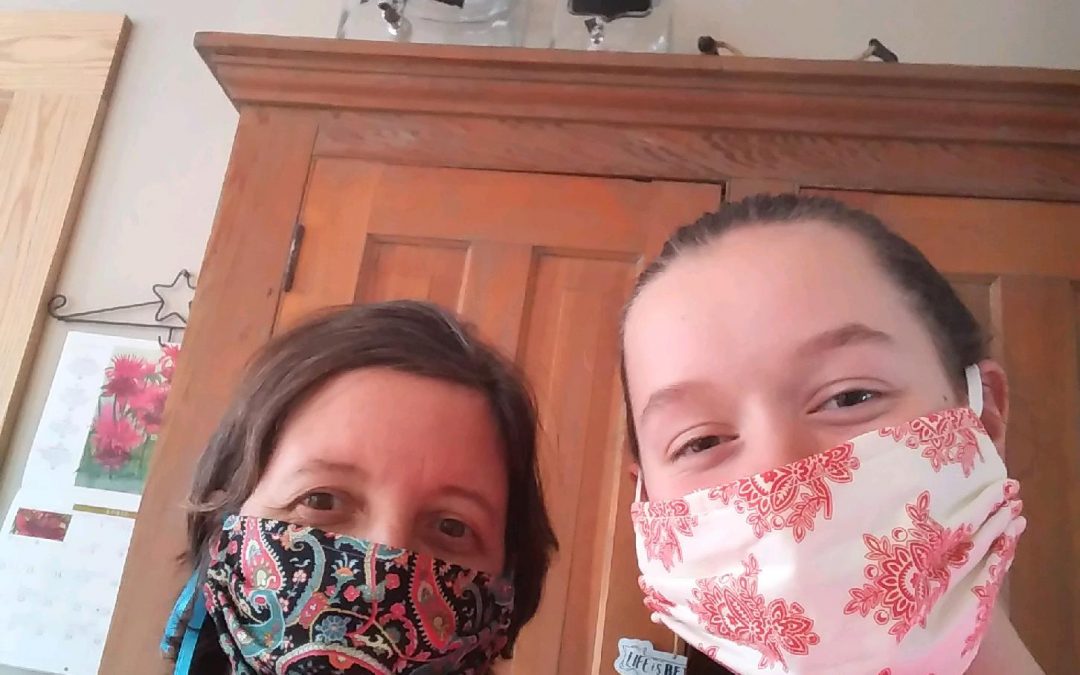 Meg Shivers and her daughter demonstrate the masks they created for Springbrook